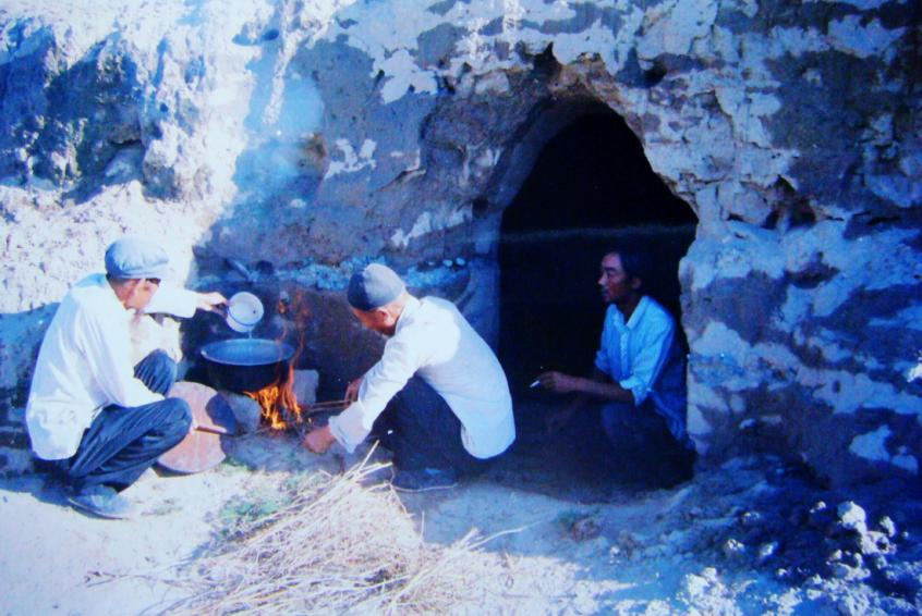 1983年，“六老漢”一代治沙人在“地窩子”生活做飯。新華社發(fā)（八步沙林場供圖）