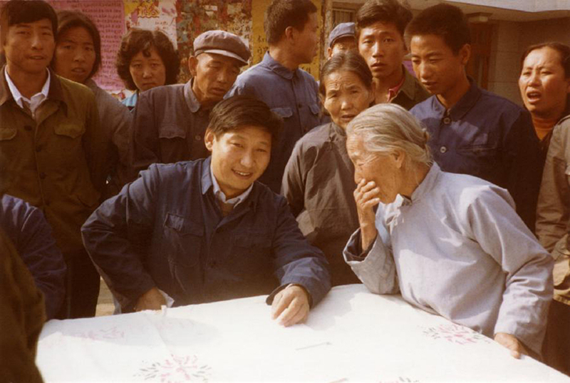 1983年，時(shí)任河北正定縣委書記的習(xí)近平（前排居中），臨時(shí)在大街上擺桌子聽取老百姓意見。