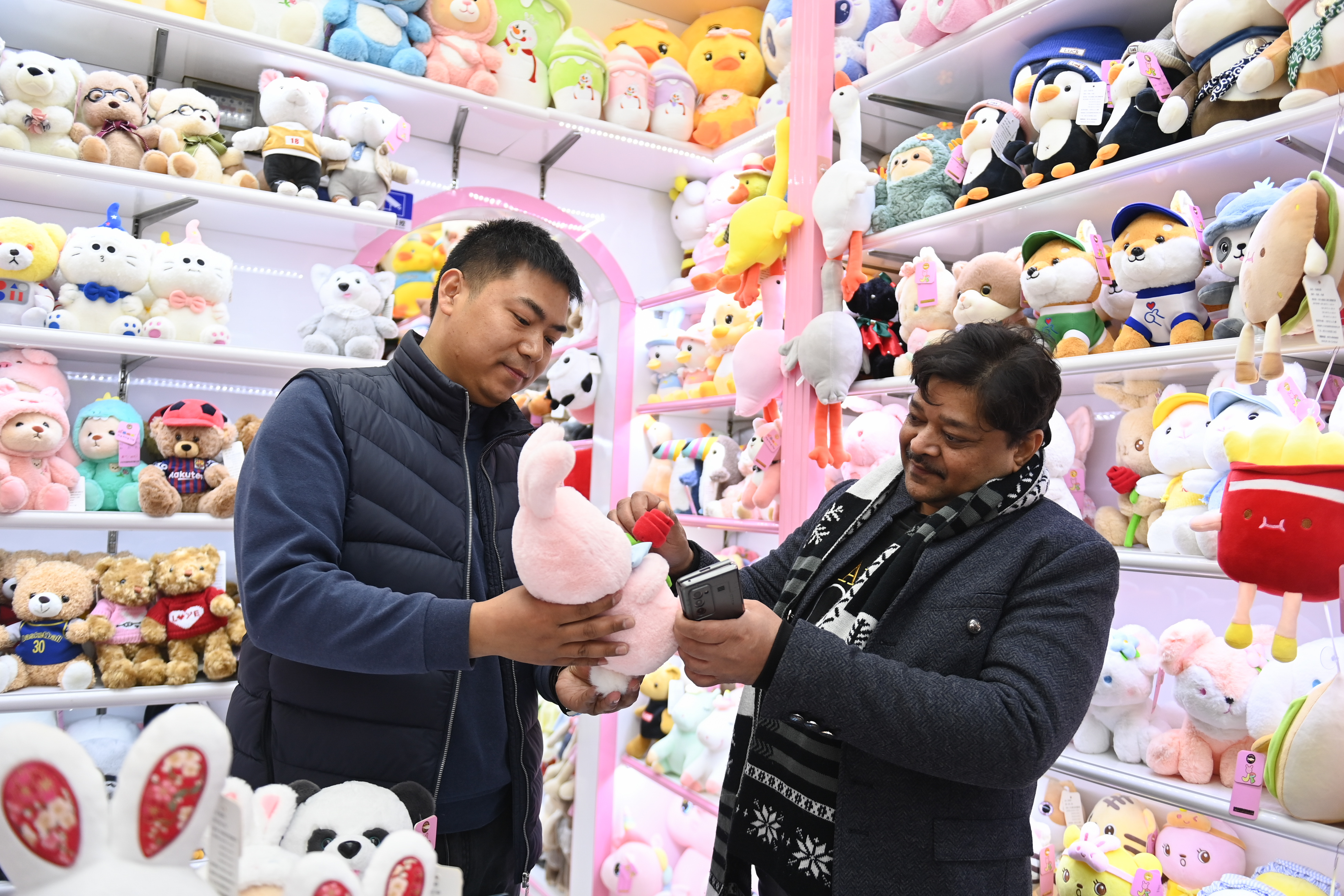 2023年2月2日，來(lái)自印度的客商（右）在義烏國(guó)際商貿(mào)城的一家玩具店鋪內(nèi)選購(gòu)。