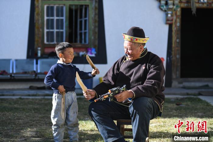 圖為米林縣扎西繞登鄉(xiāng)彩門村64歲的洛桑帶著孫子巴桑在院子的草地上玩耍?！『闻罾?攝