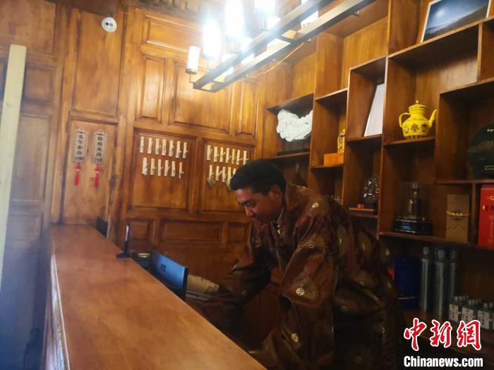 圖為桑杰才讓用電腦處理財(cái)務(wù)?！∈缝o靜 攝