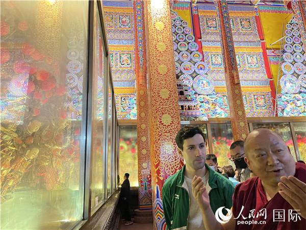 7月25日，省級非物質(zhì)文化遺產(chǎn)項目塔爾寺酥油花的代表性傳承人朋措堅參（右）在塔爾寺酥油花館講解酥油花的制作過程。人民網(wǎng) 謝瑩攝