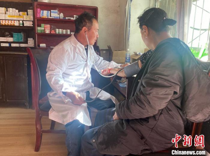 索木滾(左)為村民看病?！∪捞量h委宣傳部供圖