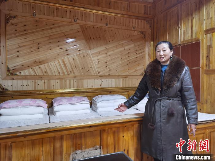 圖為德吉村村民鬧尖措介紹自家農(nóng)家樂?！∑钤鲚?攝