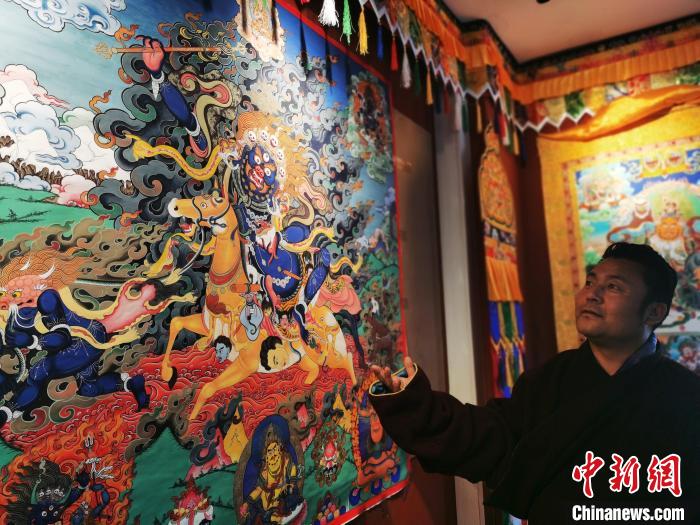 圖為久美尖措展示唐卡作品。　張?zhí)砀?攝