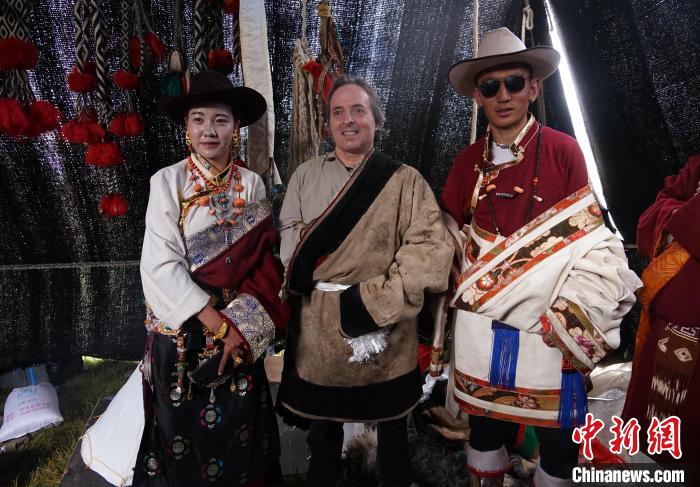 圖為一名外籍?dāng)z影師(中)身穿藏服和藏族民眾合影留念?！●R銘言 攝