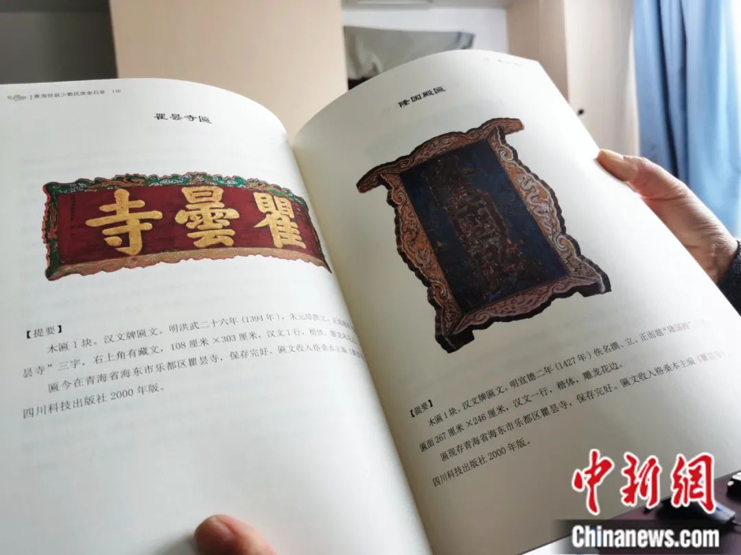 古籍保護(hù)人員展示介紹明代朱元璋撰寫的青海瞿曇寺匾(左)的出版書籍。張?zhí)砀?攝