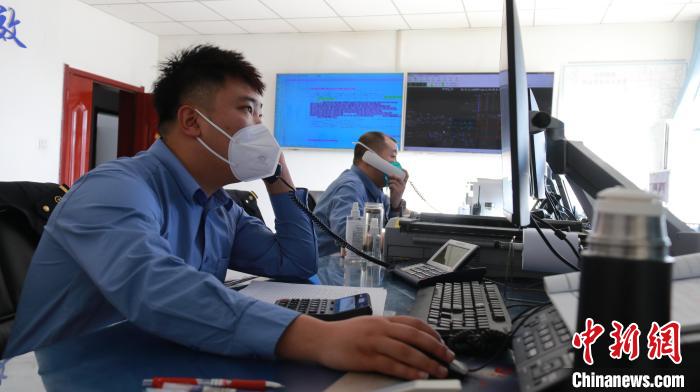 圖為貨運調(diào)度人員與外勤工作人員聯(lián)系掌握車輛裝載情況。　李生燕 攝