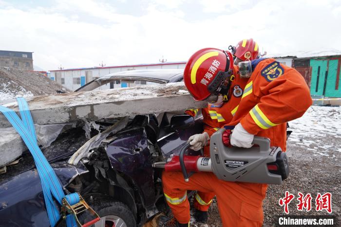 圖為地震實戰(zhàn)拉動現(xiàn)場，參演人員進行車輛破拆?！∮駱湎拦﹫D