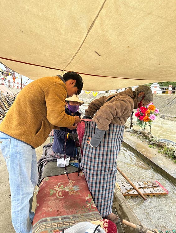 扎西奪爾登為路邊老人送去保暖圍腰。阿壩州文明辦供圖
