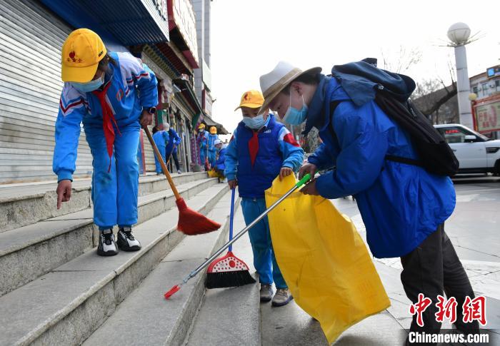圖為拉薩市小學生打掃街道?！∝暩聛硭?攝