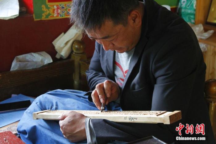 圖為7月14日，普松雕刻技藝傳承人嘎瑪曲扎正在家中進行創(chuàng)作。 <a target='_blank' ><p  align=