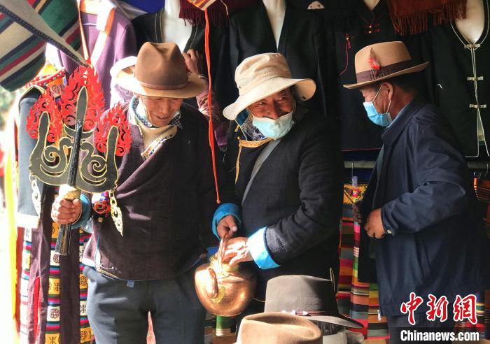 圖為三位藏族老人在集市上聊天交談?！∪轿木?攝