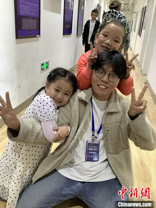 “Z世代”旦真旺加認為，拉薩是一座開放與包容的城市，記憶中的拉薩是彩色的。2021年，旦真旺加從浙江大學漢語言文學專業(yè)畢業(yè)后，他選擇回到拉薩，成為一名漢語文實習助教。圖為8月4日，旦真旺加在課間陪學生玩耍。 <a target='_blank' ><p  align=