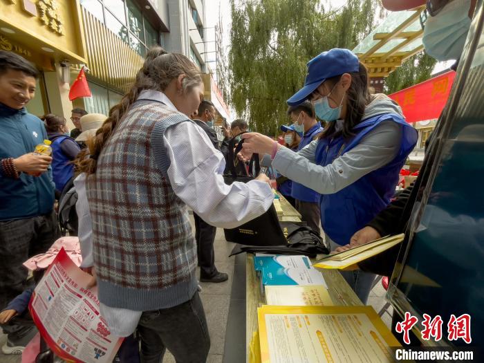圖為志愿者為市民發(fā)放網絡安全宣傳手冊?！≈x牧 攝