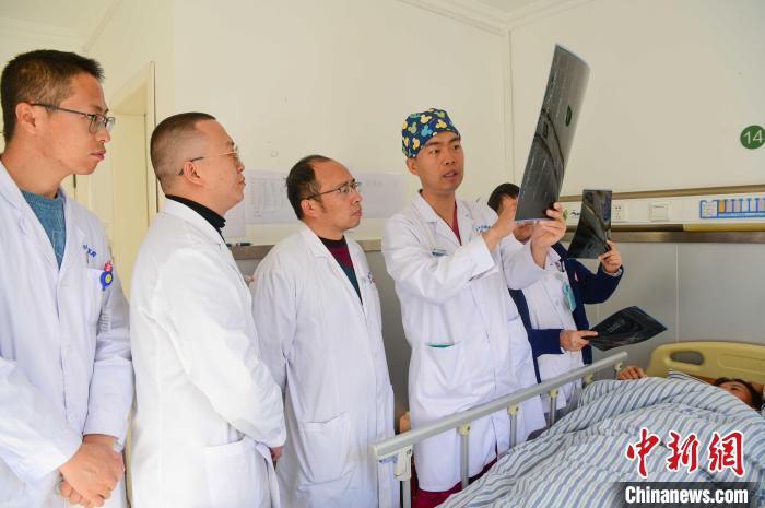 圖為何蔚副主任醫(yī)師(站右二)及團隊討論患者病情。　貢嘎來松 攝