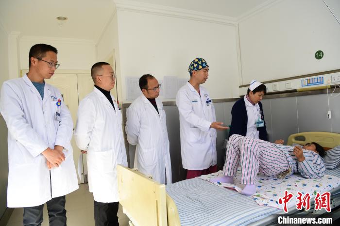 圖為何蔚副主任醫(yī)師(站右二)及團隊術后指導患者進行腰背肌鍛煉?！∝暩聛硭?攝