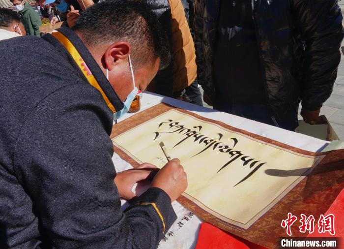 圖為書法家展示藏文書法?！∪轿木?攝