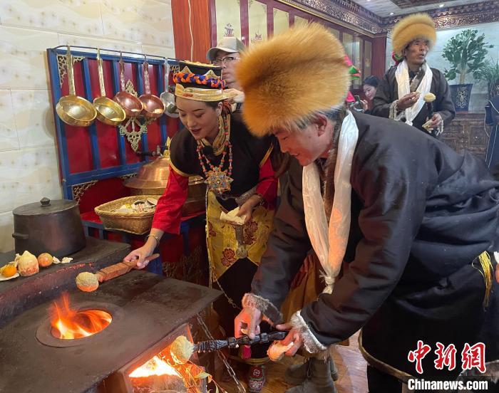 圖為人們?cè)诨鹕峡竟?jié)日美食“結(jié)達(dá)”?！∪轿木?攝