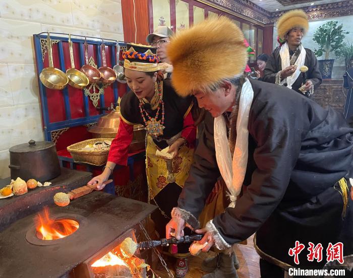 圖為人們?cè)诨鹕峡竟?jié)日美食“結(jié)達(dá)”?！∪轿木?攝