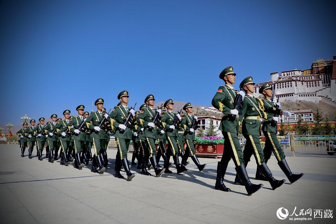 國旗護衛(wèi)隊隊員緊握鋼槍，踏著威武雄壯的步伐，走向國旗臺。人民網(wǎng) 次仁羅布攝