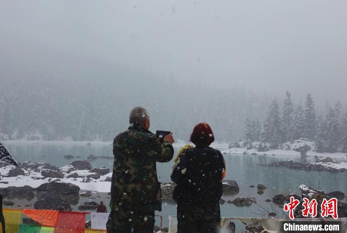 游客欣賞雪中然烏湖。　冉文娟 攝