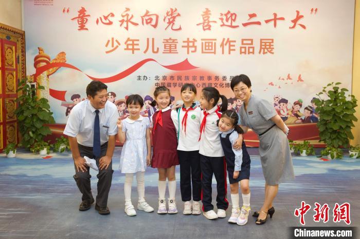 圖為與會嘉賓與入選畫作的“小作者”們在展覽上合影?！≈袊貙W(xué)研究中心供圖