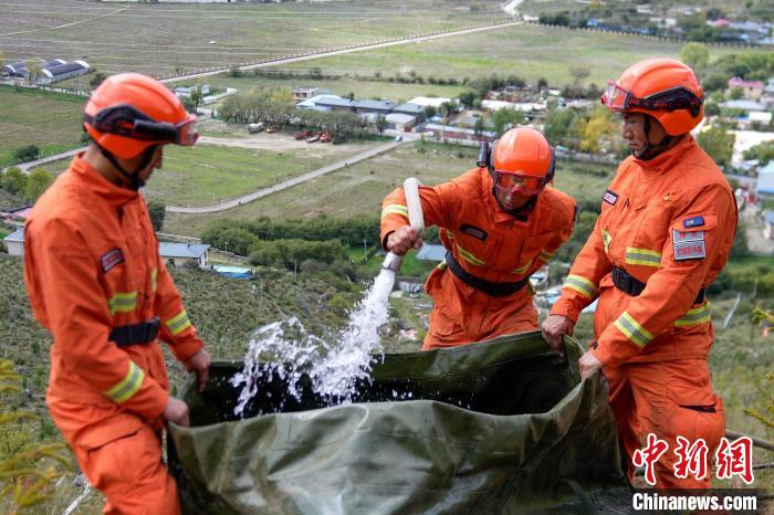 技能大練兵過程中，消防員在陡坡上向蓄水池注水?！±顕?guó)燾 攝
