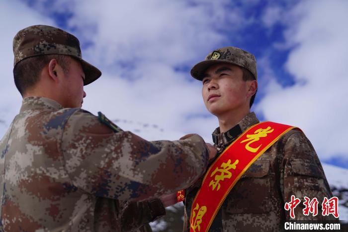 排長(zhǎng)王朝偉(圖左)給退伍老兵佩戴大紅花?！∥鞑厣侥宪姺謪^(qū)某團(tuán)供圖