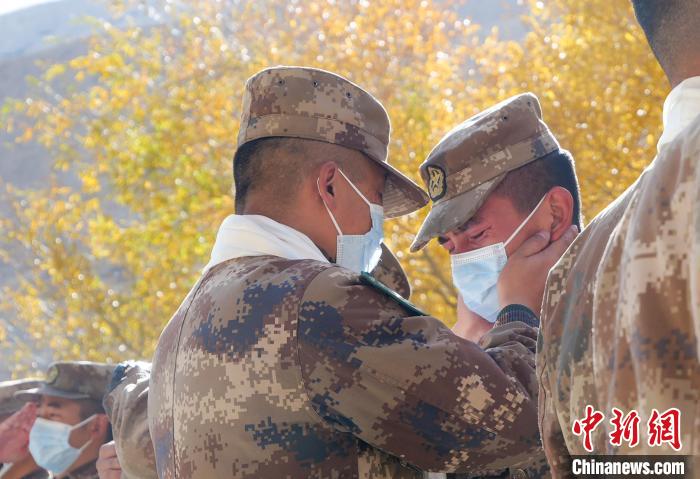 圖為什布奇邊防連退伍老兵與戰(zhàn)友相擁而泣，依依惜別?！⌒觳?攝