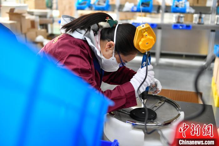 圖為工人正在組裝炊具。　貢嘎來松 攝