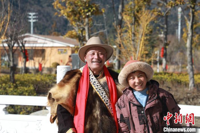 圖為林芝市巴宜區(qū)布久鄉(xiāng)仲果村村民桑杰與孫子一起參加藏歷新年活動(dòng)?！埩?攝