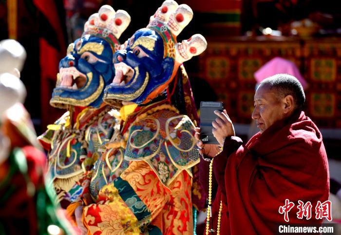 2月19日，正在拍攝跳神活動(dòng)的僧人?！±盍?攝