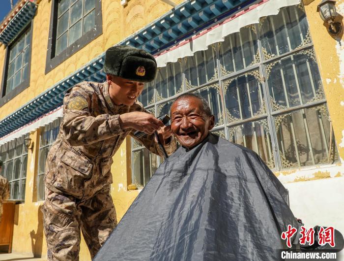 圖為阿里軍分區(qū)某邊防團(tuán)官兵為駐地群眾理發(fā)迎藏歷新年?！〉┰鰝愔?攝