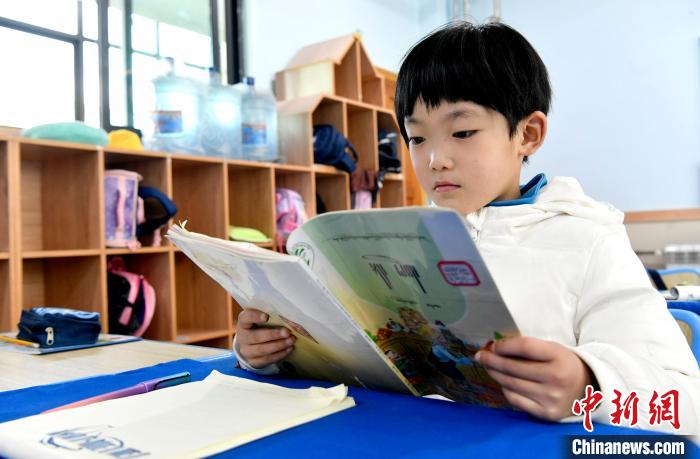 3月14日，西藏拉薩市第一小學(xué)一年級(jí)六班學(xué)生丁增樂吉在閱讀藏語課本。　李林 攝