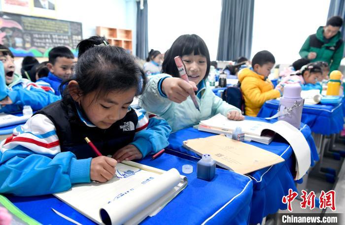 3月14日，西藏拉薩市第一小學(xué)一年級(jí)六班學(xué)生白瑪朗珍(圖左)在藏語文課上書寫藏文?！±盍?攝