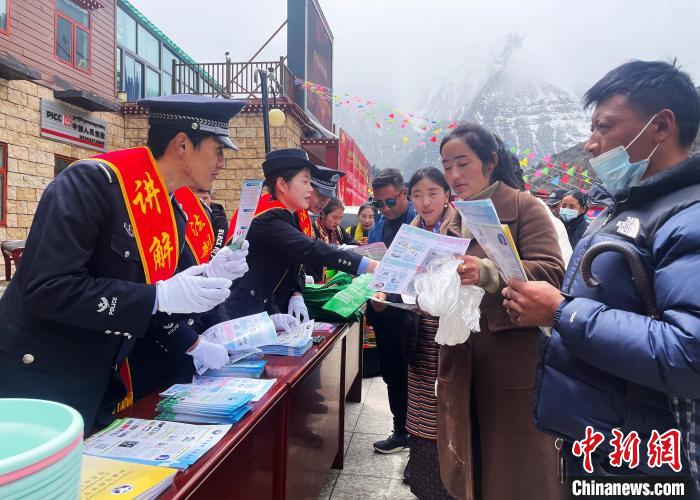 圖為山南玉麥邊境派出所民警為轄區(qū)群眾發(fā)放法律知識(shí)宣傳單?！＄婗?　攝