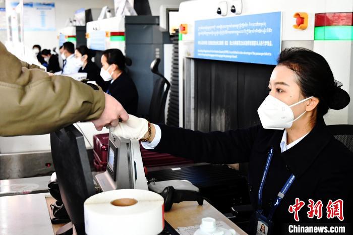 圖為機場工作人員為旅客辦理行李托運。　周航 攝
