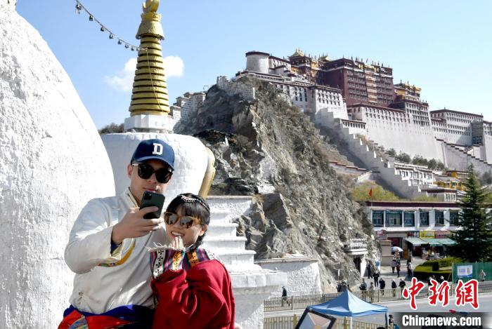 4月17日，游客身著藏式元素服裝在拉薩布達拉宮觀景臺拍照留念?！±盍?攝