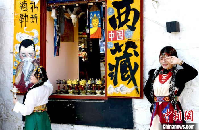 4月17日，游客身著藏式元素服裝在拉薩八廓街拍照留念?！±盍?攝