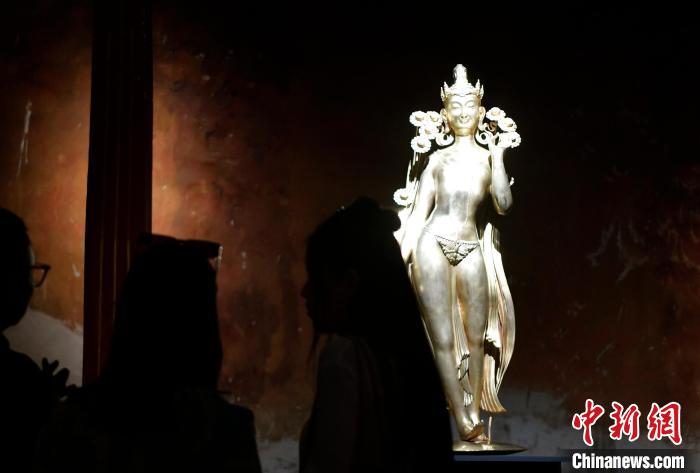 圖為觀眾正在欣賞展覽中的雕塑作品《八萬四千年》?！±盍?攝