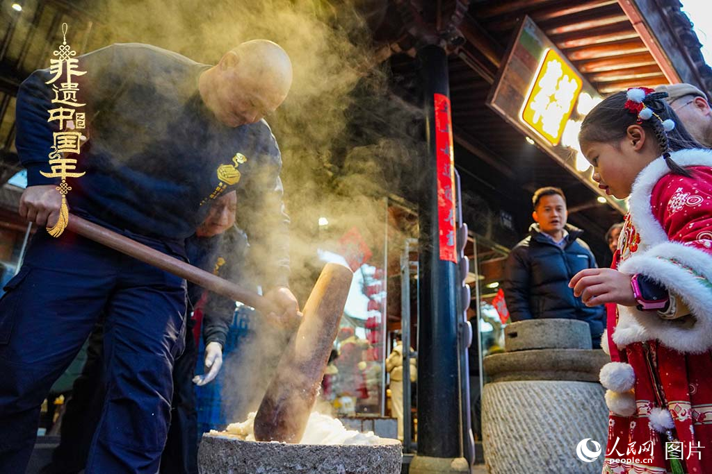 2025年1月29日，浙江省寧波市江北區(qū)慈城古縣城，市民和游客觀看搗年糕。人民網(wǎng) 章勇濤攝