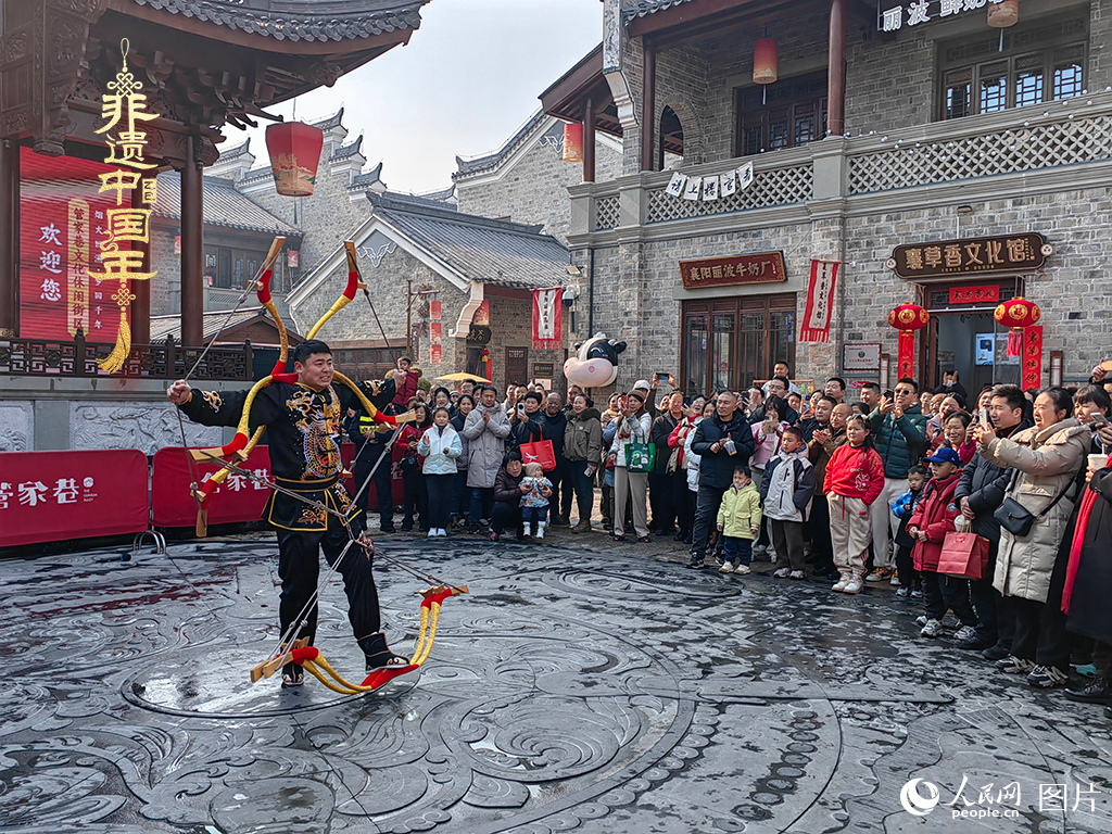 2025年1月29日，湖北襄陽市管家巷，老北京天橋大刀張舉大刀拉硬弓第五代傳承人現(xiàn)場表演，一次拉開6張弓，引來游客喝彩。人民網(wǎng)記者 郭婷婷攝