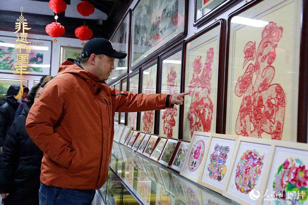 2025年1月23日，游客在天津楊柳青古鎮(zhèn)欣賞傳統(tǒng)剪紙作品，感受指尖上的古老藝術(shù)。人民網(wǎng)記者 崔新耀攝